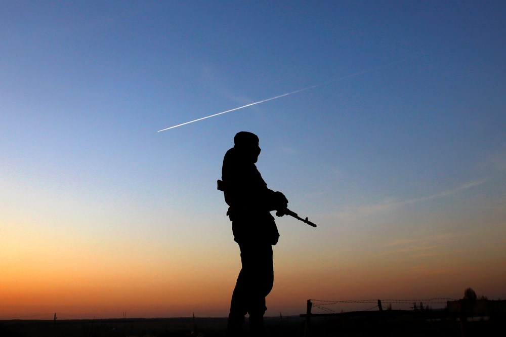 A Ukrainian soldier stands guard at a military camp the Ukrainian Army forces set up close to the Russian border, March 21, 2014, in east Ukraine.