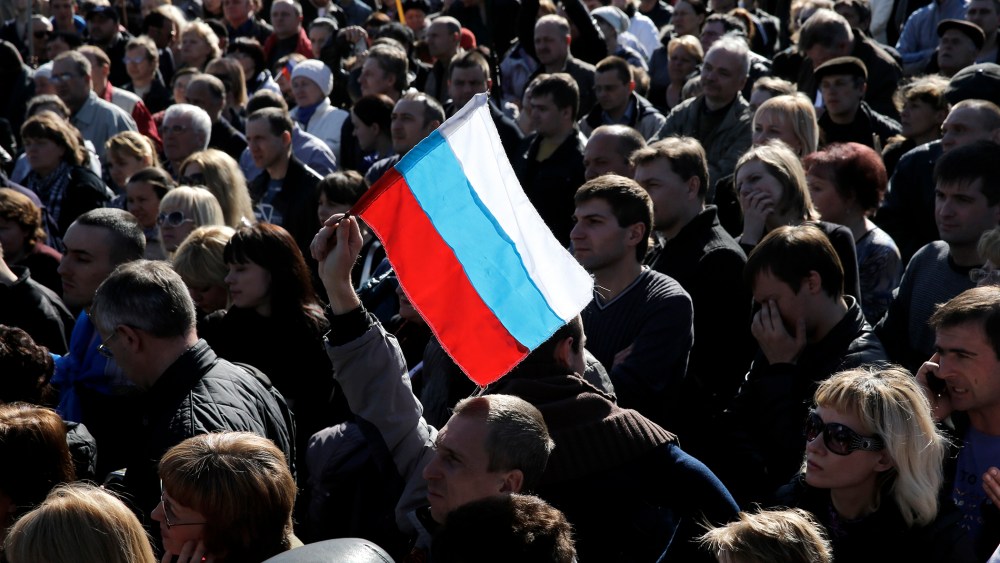 A pro-Russian activist holds a Russian flag during a rally in Donetsk's Lenin square March 23, 2014.