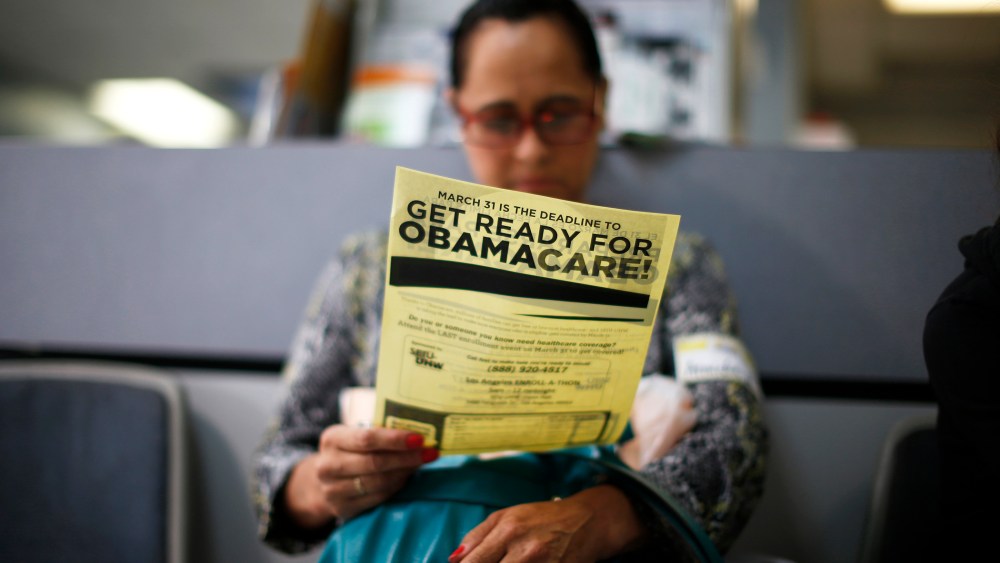 A woman reads a leaflet at a health insurance enrollment event in Cudahy, California March 27, 2014.
