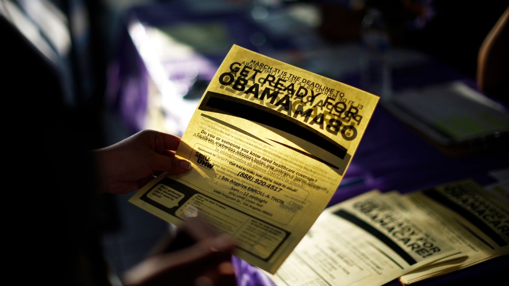 A woman picks up a leaflet at a health insurance enrollment event in Cudahy, Calif., March 27, 2014.