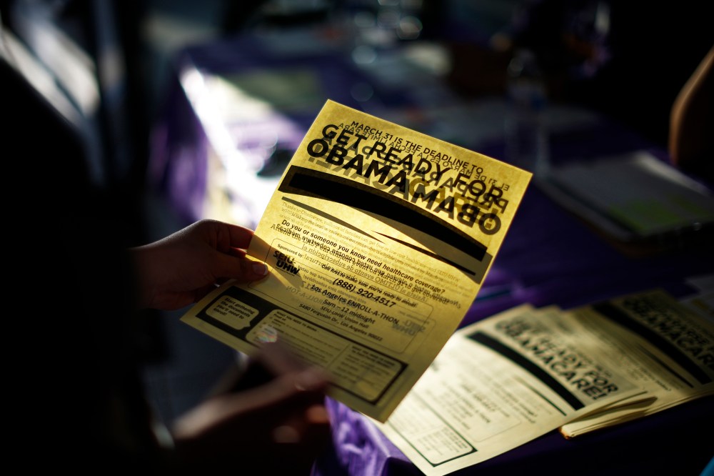 A woman picks up a leaflet at a health insurance enrollment event in Cudahy, Calif., March 27, 2014.