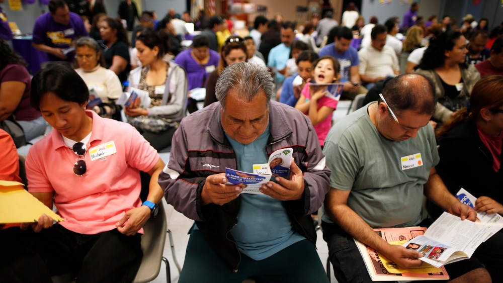 Dominguez, who does not have health insurance, reads a pamphlet at a health insurance enrollment event in Cudahy, California