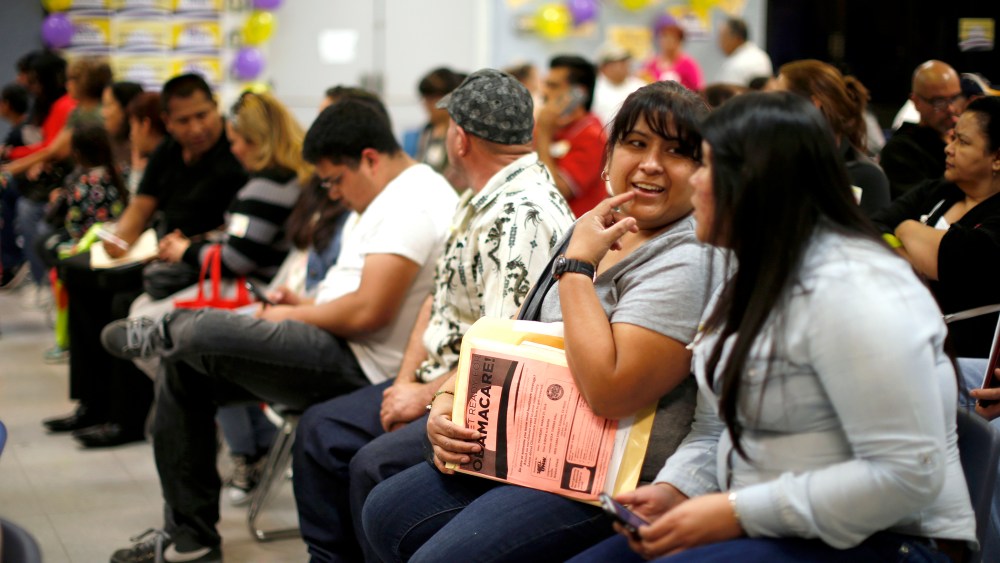 People wait in line at a health insurance enrollment event in Cudahy, Calif. on March 27, 2014.