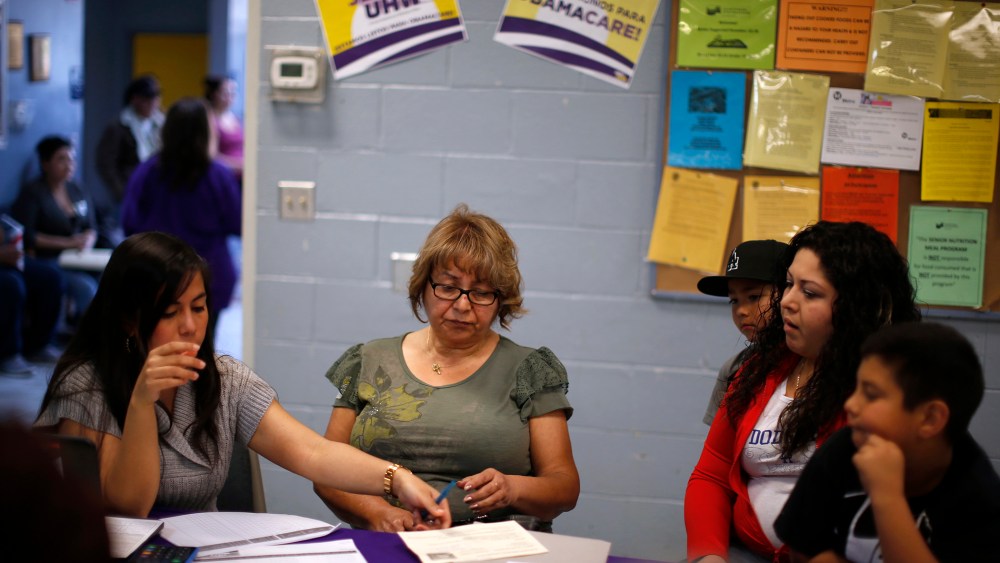 Maria Renteria (L), explains health insurance options to Manuela Ruiz and her daughter at an enrollment event in Cudahy, California March 27, 2014.