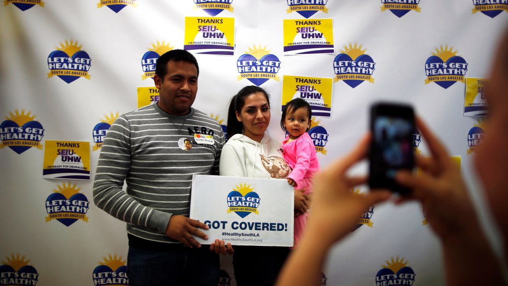 Enrique Gonzalez, 22, (L-R), Janet Regalado, 21, and their nine-month-old daughter Kayleen Gonzalez pose for a photo after signing up for health insurance at an enrolment event in Commerce, California March 31, 2014.