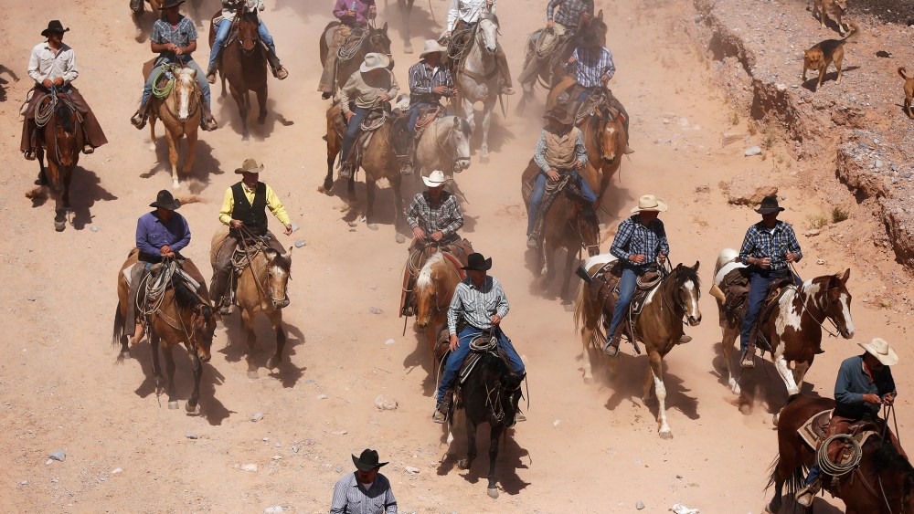 Protesters fall back from the gates of the Bureau of Land Management's base camp where seized cattle, that belonged to rancher Cliven Bundy, were being held at near Bunkerville, Nevada April 12, 2014.