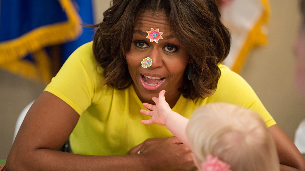 U.S. first lady Obama has stickers put on her face by 20-month-old Oppelt during visit with children at Fisher House at Walter Reed National Military Medical Center in Bethesda