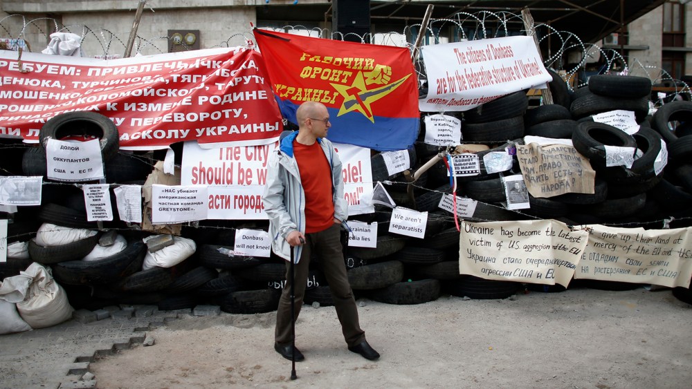 A pro-Russia protester stands at a barricade outside a regional government building in Donetsk