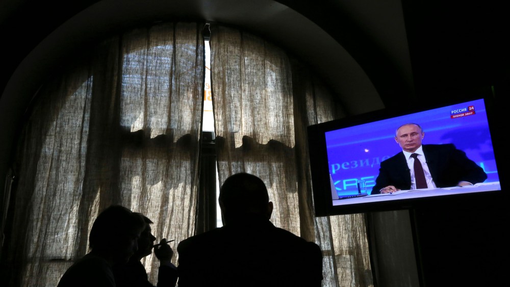 People look at a screen at a media centre during Russian President Vladimir Putin's live broadcast in Moscow on April 17, 2014.