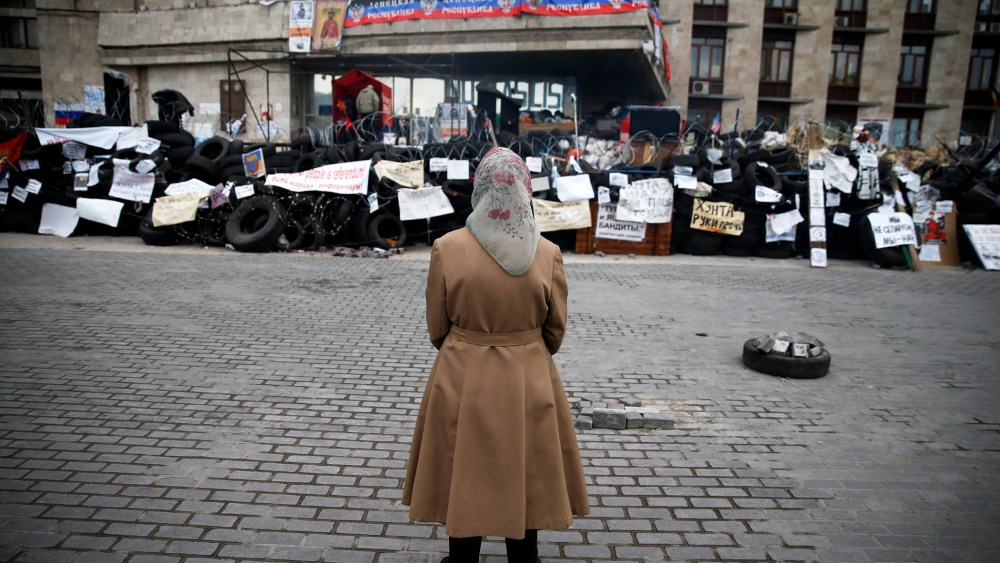 A woman stands in front of a barricade outside a regional government building in Donetsk, in eastern Ukraine, April 20, 2014.