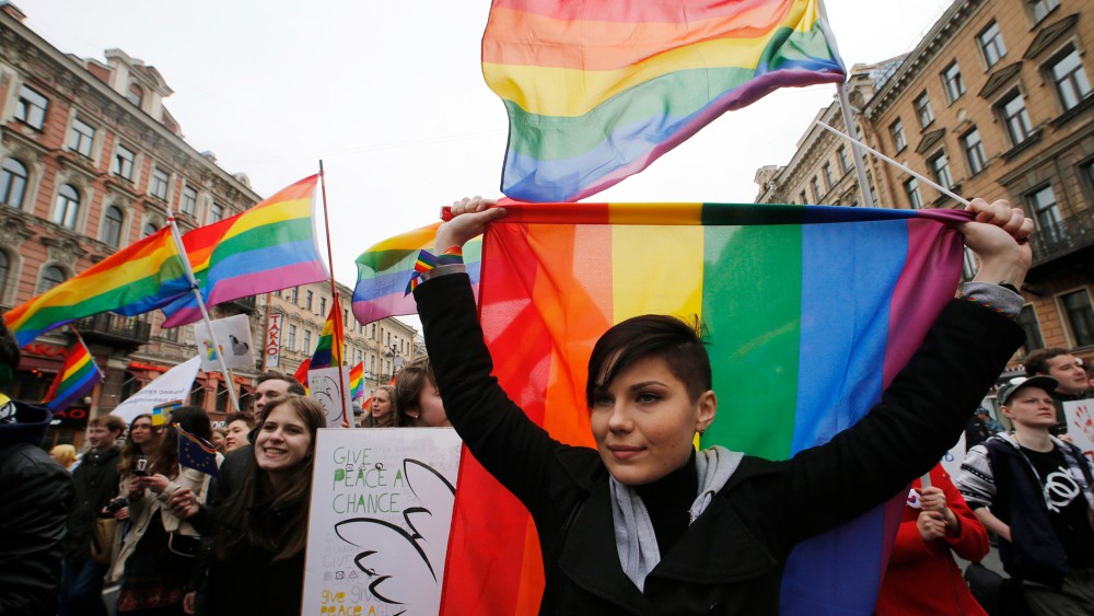 Gay rights activists march with flags and placards during a May Day rally in St. Petersburg