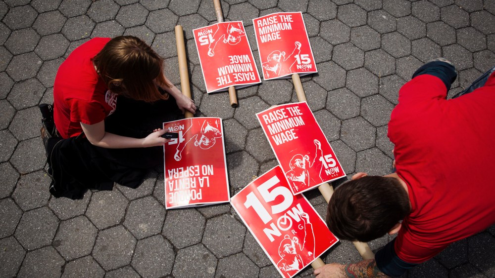Demonstrators prepare signs supporting the raising of the federal minimum wage during May Day demonstrations in New York on May 1, 2014.