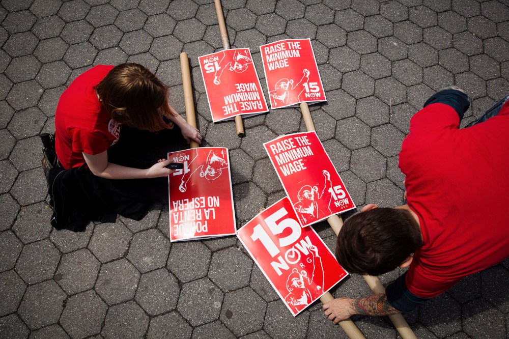 Demonstrators prepare signs supporting the raising of the federal minimum wage during May Day demonstrations in New York on May 1, 2014.