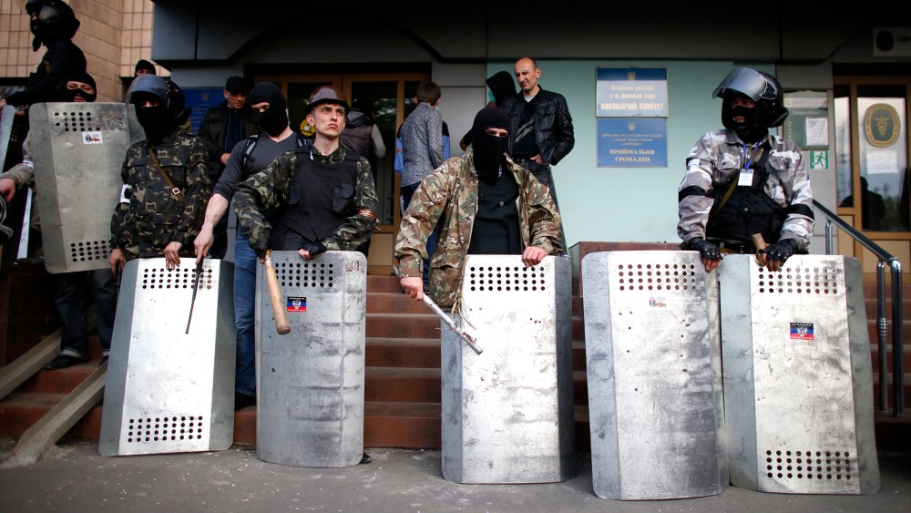 Pro-Russia protesters stand guard at the entrance of the district council building in Donetsk