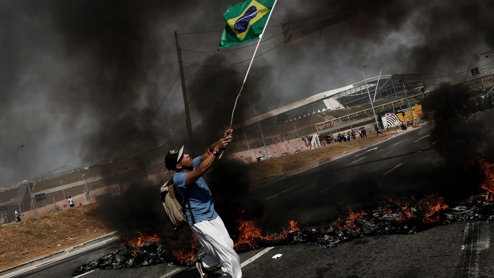 A man carries a flag of Brazil during a protest against the World Cup in Sao Paulo.