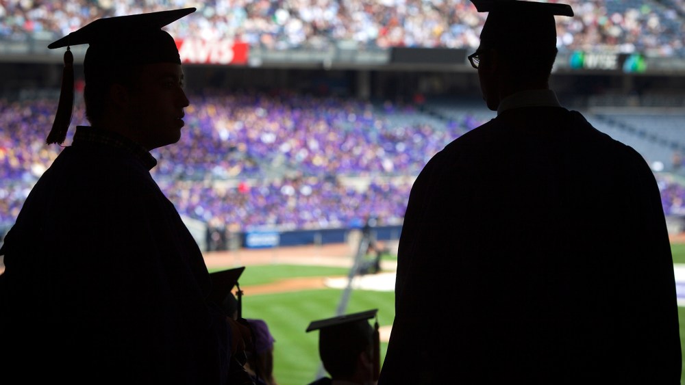 Graduates from New York University are silhouetted in the stands of Yankee Stadium during a commencement ceremony in the Bronx borough of New York.