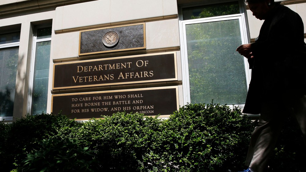 The sign in the front of the headquarters building at the Department of Veteran Affairs is seen as a woman walks past in Washington, D.C., May 23, 2014.