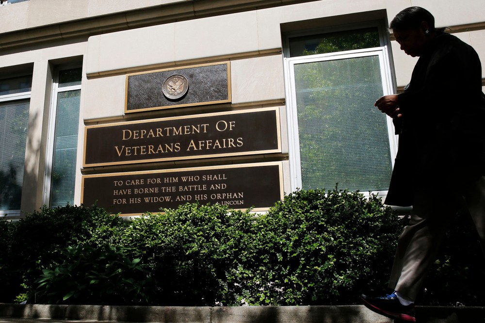 The sign in the front of the headquarters building at the Department of Veteran Affairs is seen as a woman walks past in Washington, D.C., May 23, 2014.