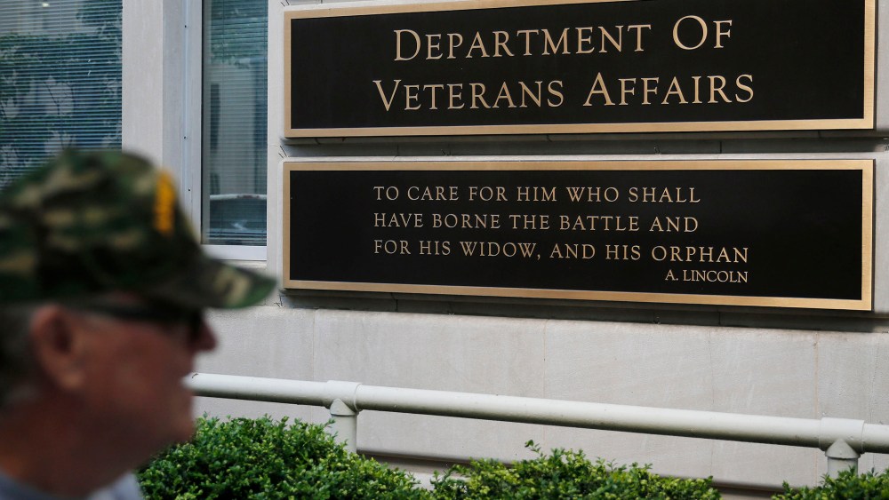 The sign in the front of the headquarters building at the Department of Veteran Affairs is seen as a man walks past in Washington