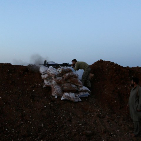 A rebel fighter takes a position as he fires his weapon towards forces loyal to Syria's President Bashar al-Assad who are stationed in Wadi al-Deif military camp in Idlib province June 1, 2014.
