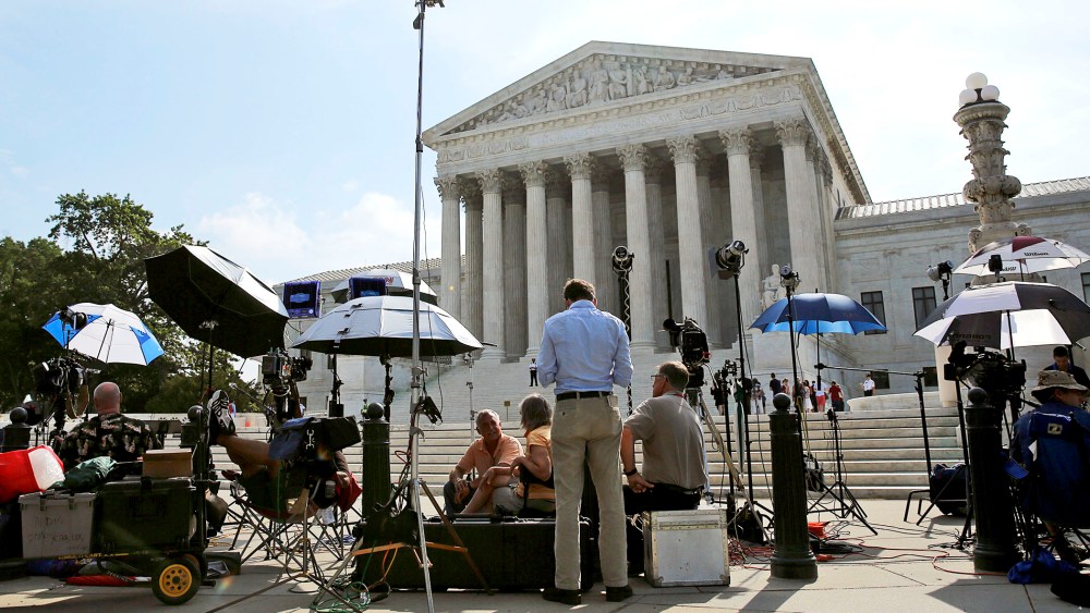 Numerous news crews await outside the Supreme Court in Washington June 25, 2014.