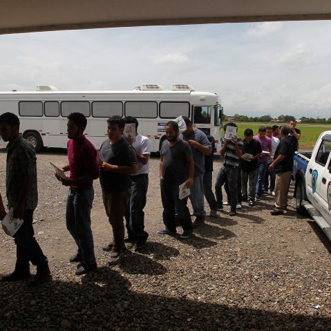 Deportees line up at the Care Center for Returning Migrants (CAMR) after arriving on an immigration flight from the U.S., at the international airport in San Pedro Sula