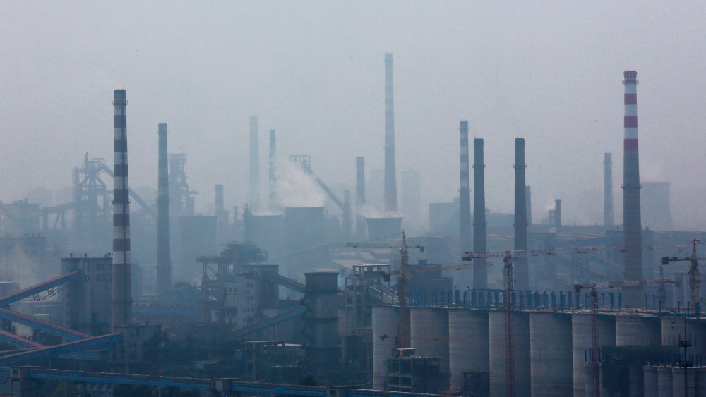 A steel factory is seen in smog during a hazy day in Anshan, Liaoning province, China on June 29, 2014.