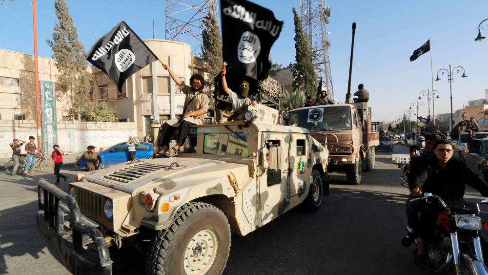 Militant Islamist fighters take part in a military parade along the streets of Syria's northern Raqqa province