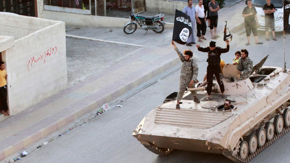 Militant Islamist fighters take part in a military parade along the streets of northern Raqqa province