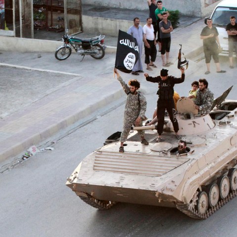 Militant Islamist fighters take part in a military parade along the streets of northern Raqqa province on June 30, 2014.