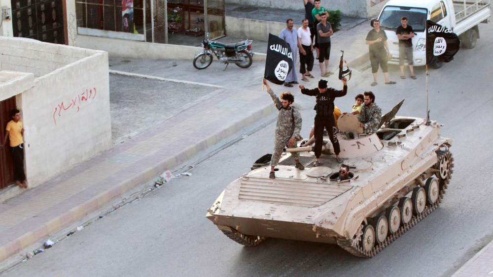 Militant Islamist fighters take part in a military parade along the streets of northern Raqqa province June 30, 2014.