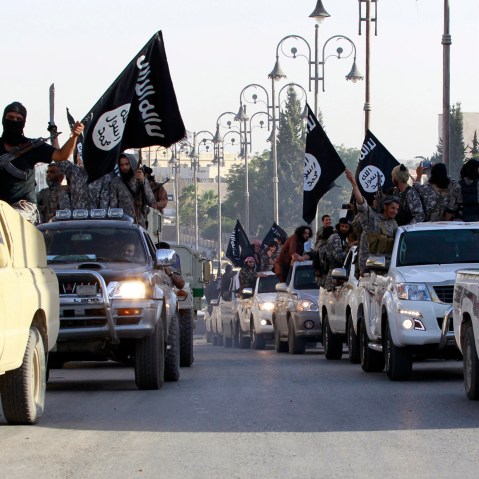 Militant Islamist fighters parade on military vehicles along the streets of northern Raqqa province June 30, 2014. (Photo by Reuters)