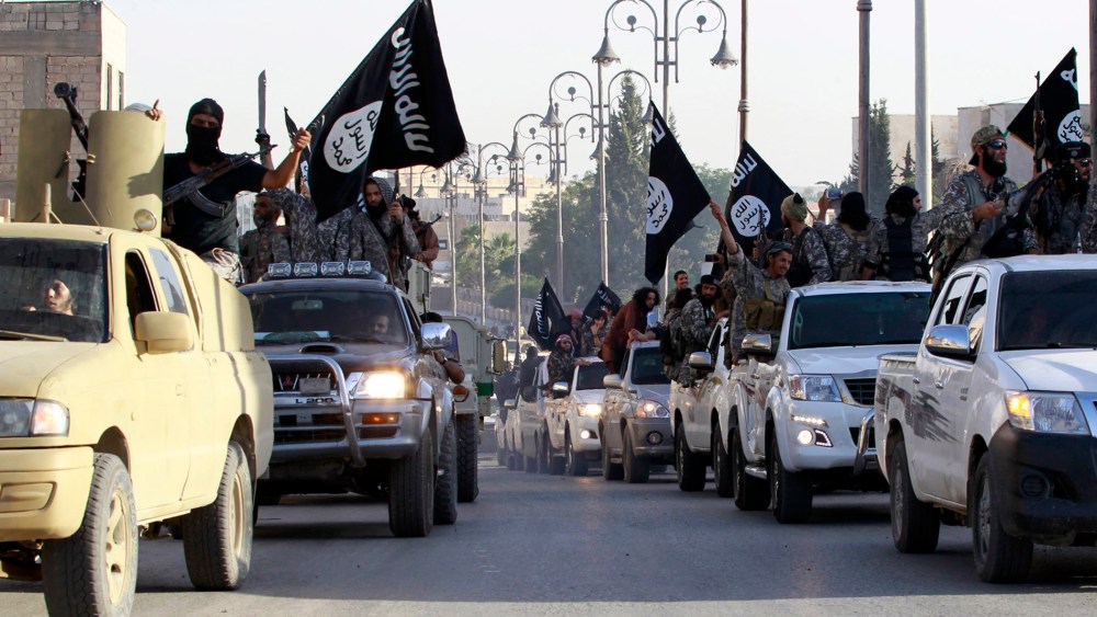 Militant Islamist fighters parade on military vehicles along the streets of northern Raqqa province June 30, 2014. (Photo by Reuters)