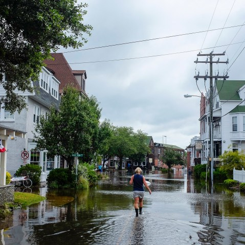 A woman walks down a flooded street after Hurricane Arthur blew through in Manteo, North Carolina July 4, 2014.