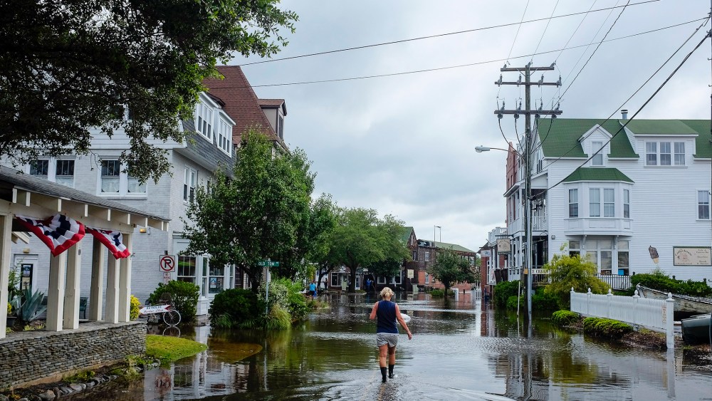 A woman walks down a flooded street after Hurricane Arthur blew through in Manteo, North Carolina July 4, 2014.
