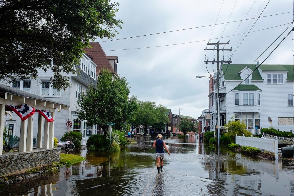 A woman walks down a flooded street after Hurricane Arthur blew through in Manteo, North Carolina July 4, 2014.