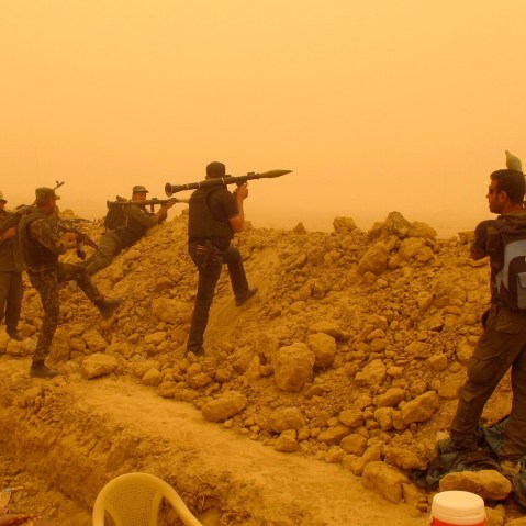 Armed Shia volunteers from brigades loyal to radical cleric Muqtada al-Sadr, take their positions during a military advance in areas under the control of militants of the Islamic State, formerly known as the Islamic State in Iraq and Syria on the outskirt