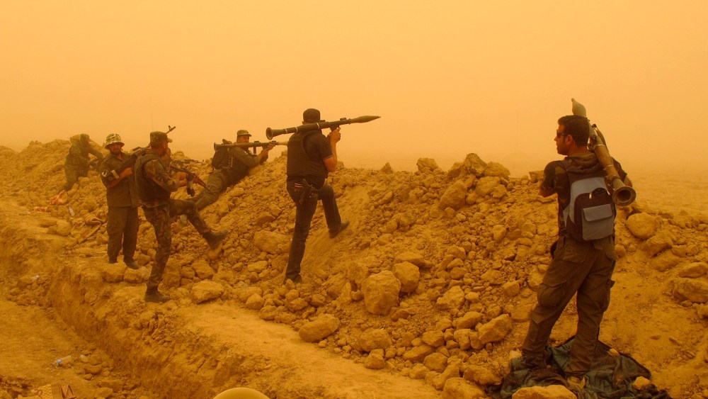 Armed Shia volunteers from brigades loyal to radical cleric Muqtada al-Sadr, take their positions during a military advance in areas under the control of militants of the Islamic State, formerly known as the Islamic State in Iraq and Syria on the outskirt