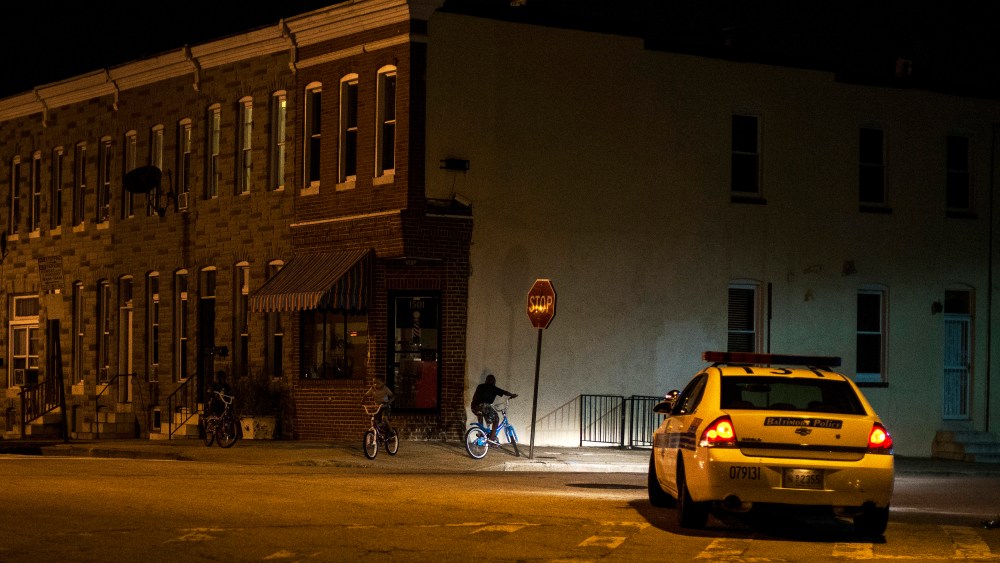 Police patrol a residential neighborhood in east Baltimore minutes after a curfew law took effect in Baltimore