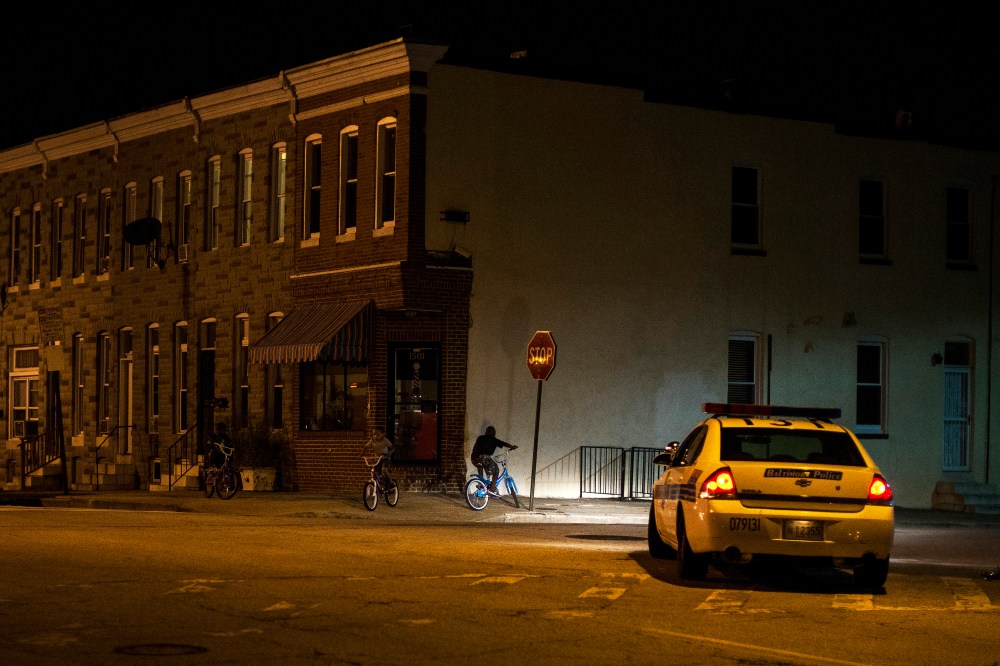 Police patrol a residential neighborhood in east Baltimore minutes after a curfew law took effect in Baltimore
