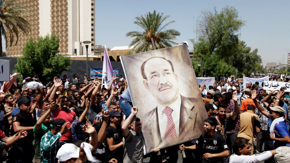 People carry portraits of Nuri al-Maliki as they gather in support of him in Baghdad on Aug. 13, 2014.