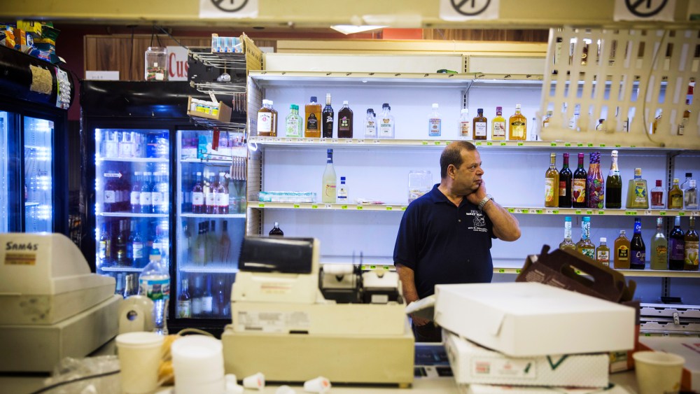 Sam's Meat Market & More employee Steve Sumad rubs his neck as he surveys damage caused by looters the night before in Ferguson, Missouri, August 16, 2014.