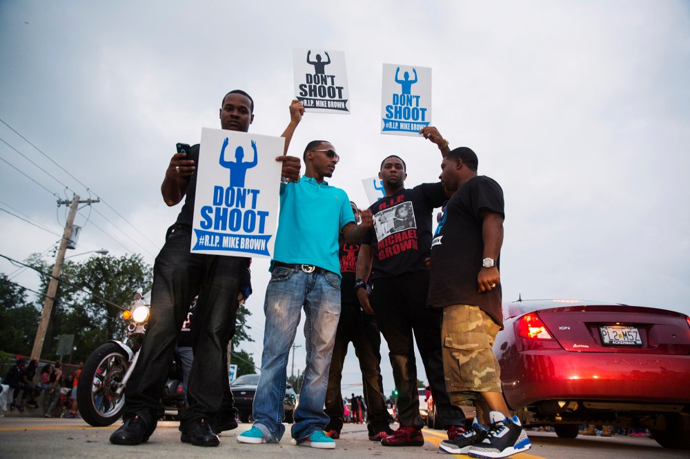 Demonstrators gesture and chant as they continue to react to the shooting of Michael Brown in Ferguson, Missouri August 17, 2014.