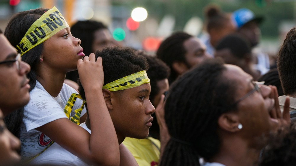 Demonstrators listen to rapper Nelly during a peaceful march in reaction to the shooting of Michael Brown, near Ferguson, Mo., August 18, 2014.