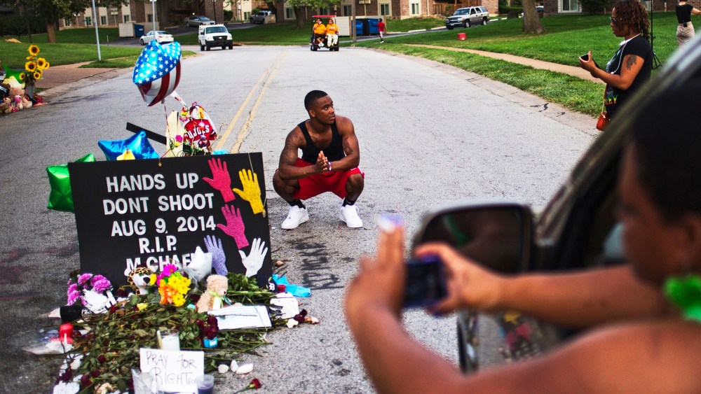 A nearby resident puts his hands together in prayer at a makeshift memorial near the site where unarmed teen Michael Brown was killed in Ferguson, Missouri, Aug. 22, 2014.