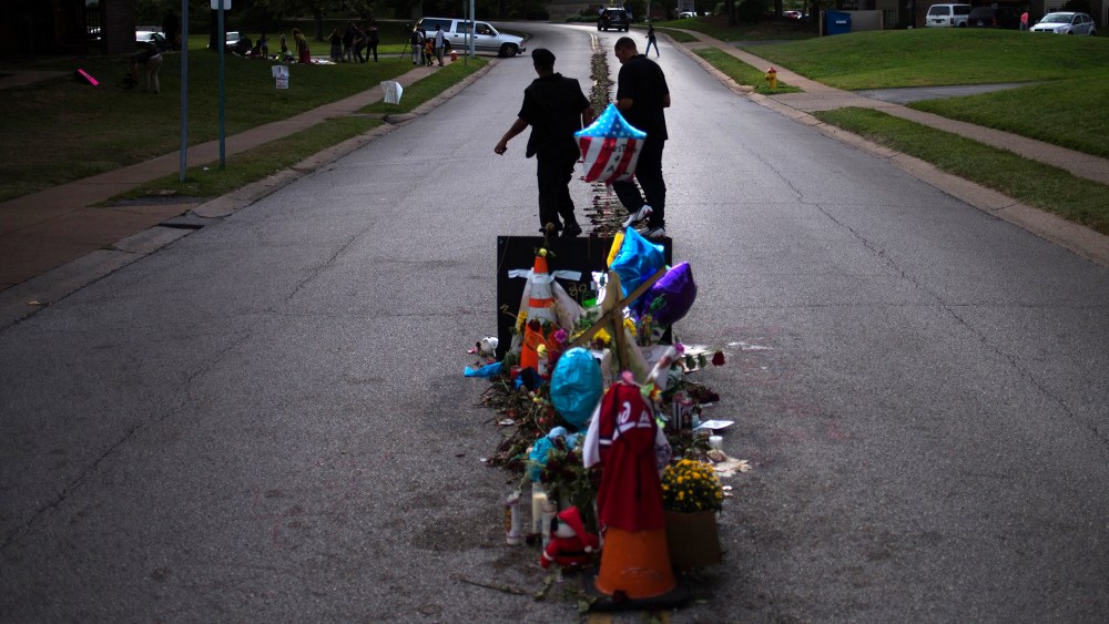 Men walk past a makeshift memorial near the site where unarmed teen Michael Brown was shot dead in Ferguson