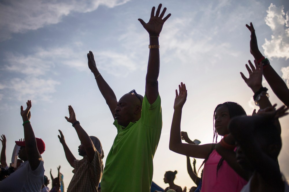 Supporters of Michael Brown, who was killed by a police officer on August 9, raise their hands in solidarity as they are led by Tracy Martin, father of Trayvon Martin, a Florida teenager shot dead in 2012, at the the Peace Fest 2014 rally in St. Louis, Mo