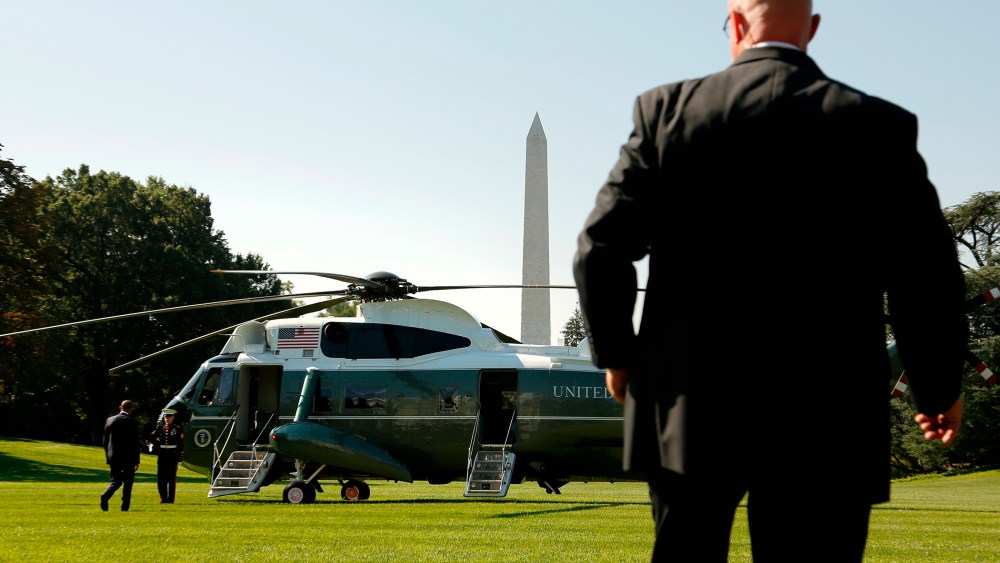A Secret Service agent watches as U.S. President Barack Obama boards the Marine One helicopter, Aug. 26, 2014.
