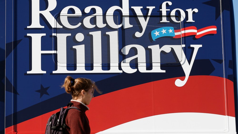 A woman walks by a bus supporting former U.S. Secretary of State Hillary Clinton at the location for Senator Tom Harkin's 37th Steak Fry in Indianola