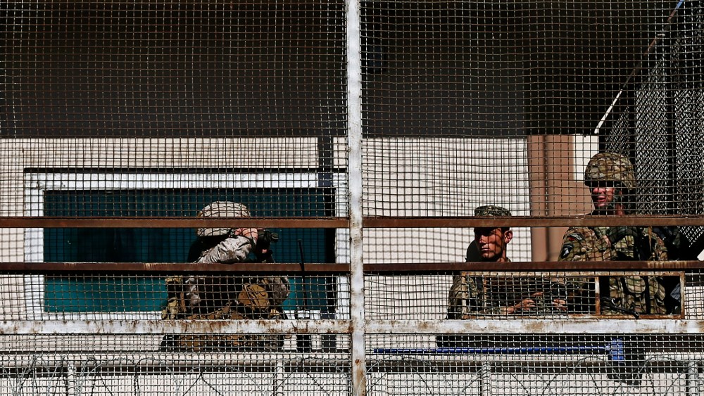 A U.S. soldier (R) and Afghan security forces keep watch from a security tower at the site of a suicide attack in Kabul September 16, 2014.